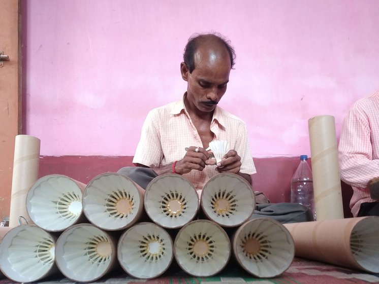 Right: Prabash Shyashmal checks each shuttlecock for feather alignment and thread placement.