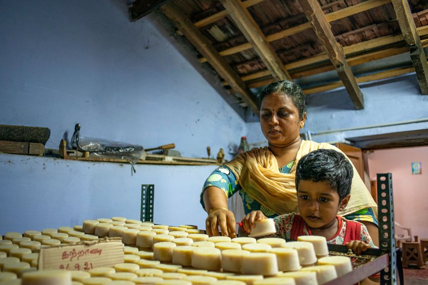 Gomathy and her daughter shelving soaps in the workshop