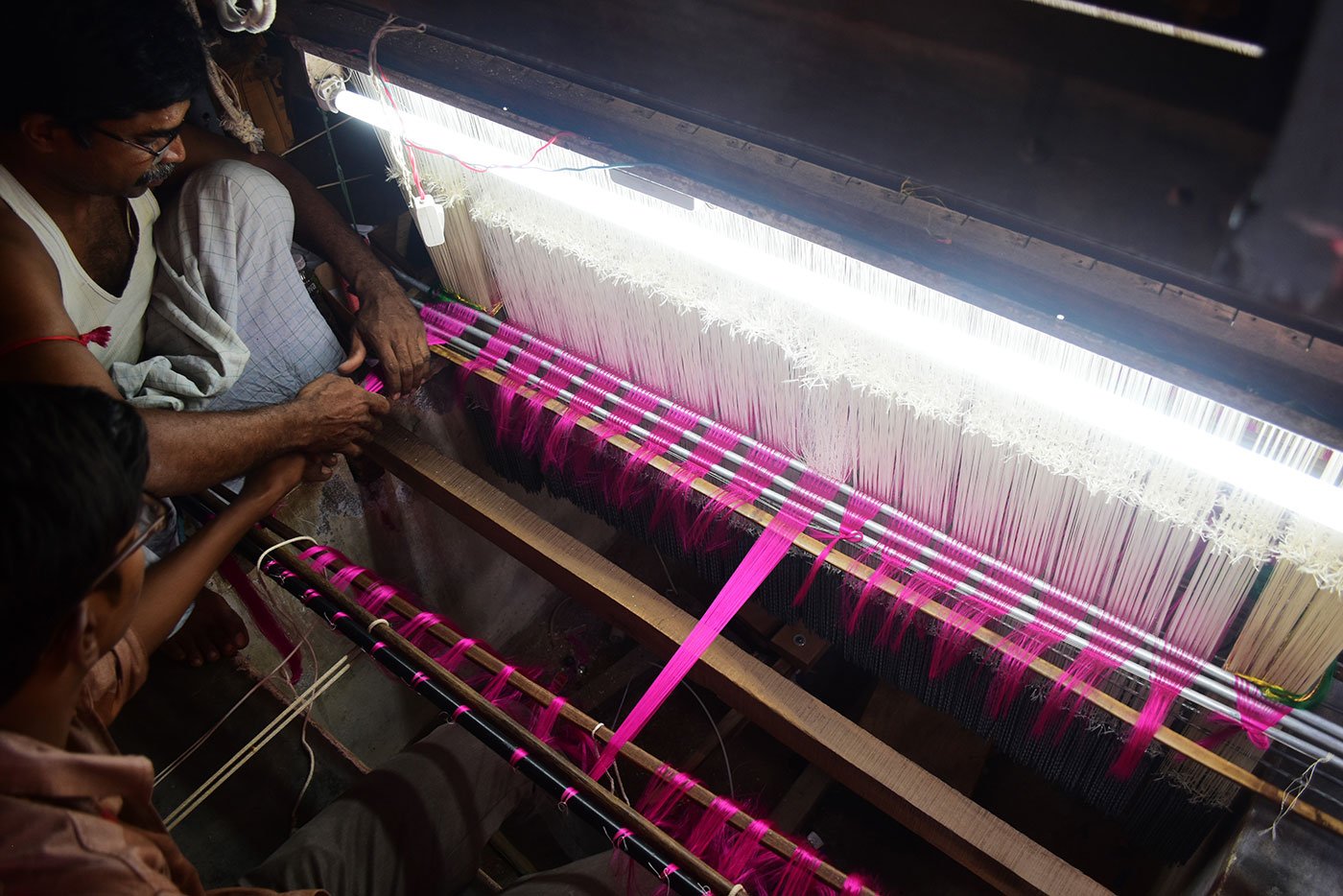 Devasenathipathy Rajagopal finishing a saree and cutting the cloth from the loom. His son studies at a high school in Arni and helps with the weaving 