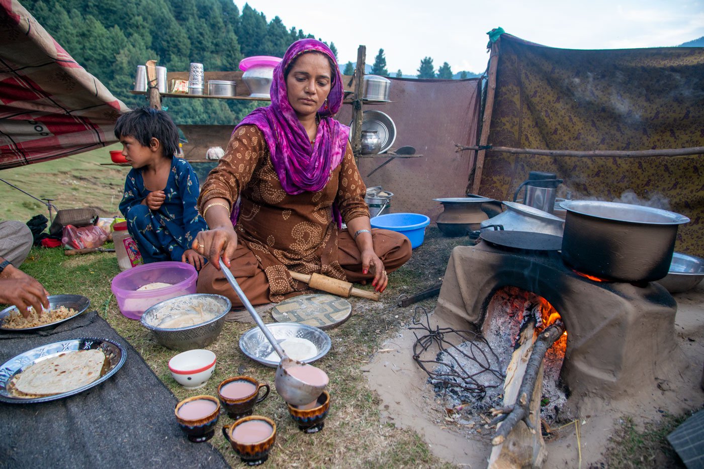 In her makeshift camp, Khalda Begum serving tea made with goat milk