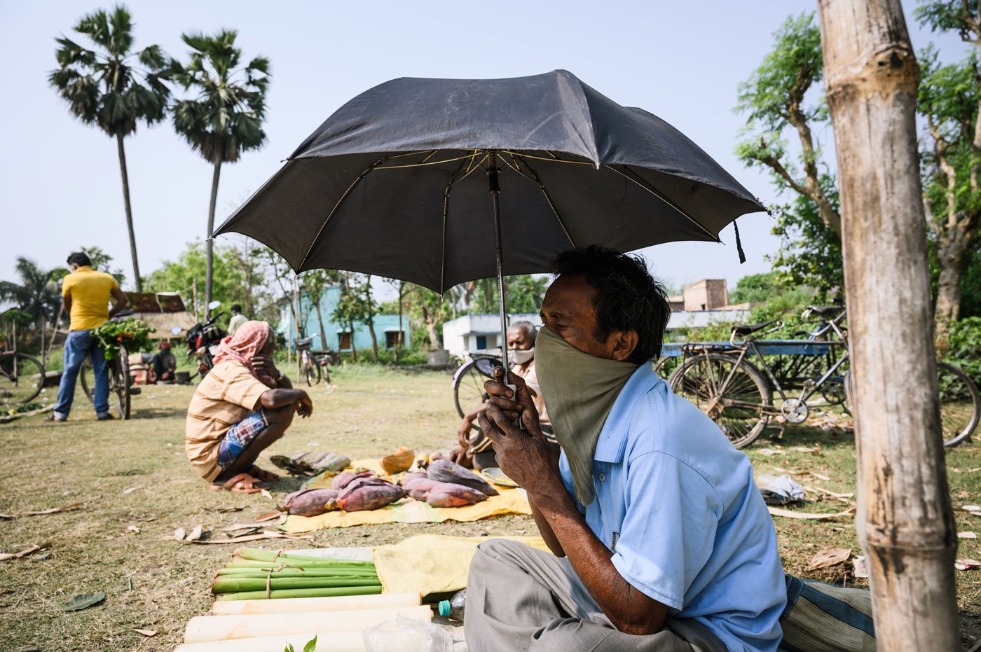 Without a plastic sheet to use as a temporary shade from the sun, Sadananda Roy, 58, sits in middle of the field with a few vegetables holding an umbrella. He was a domestic worker in Delhi, but came home before the lockdown. His only income now is from selling a few vegetables, which fetches him Rs 50-100 a day. "I didn't come here regularly because some days I don't have vegetables to sell,” he says. “I don't know what will happen in the future.”