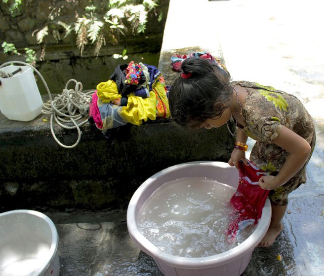 Left: Young girls help their mothers not only to fetch water, but also in other household tasks. Women and girls of the fishing community in Killabandar village, Palghar district, spend hours scraping the bottom of a well for drinking water, and resent that their region’s water is diverted to Mumbai city.