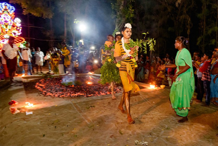 Left: Fire-walkers, smeared with sandalwood paste and carrying large bunches of neem leaves, walk over the burning embers one after the other; some even carry little children.