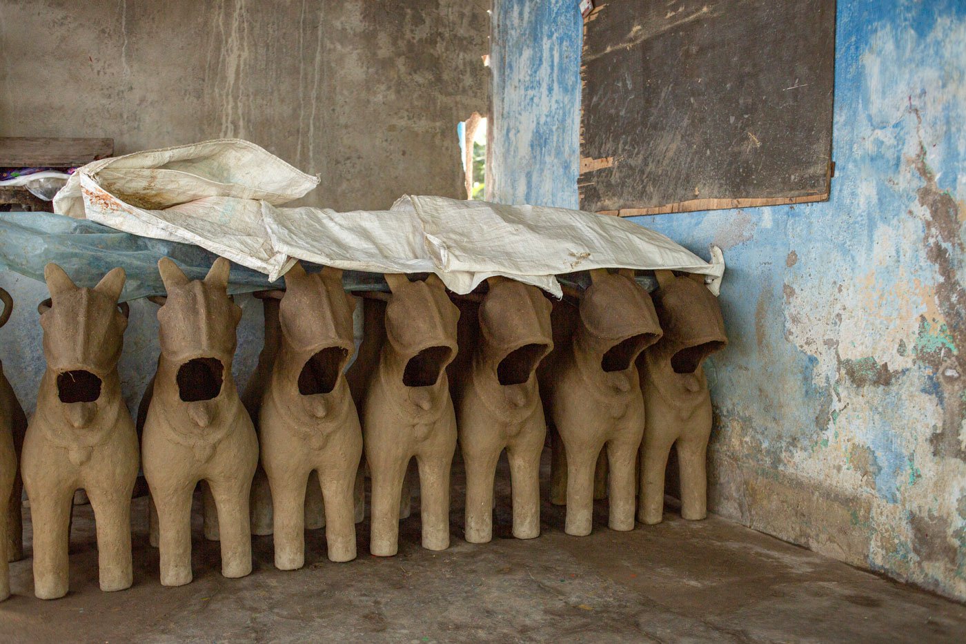 The elephant and horses are the base for the idols; they are covered to protect them from harsh sunlight.
