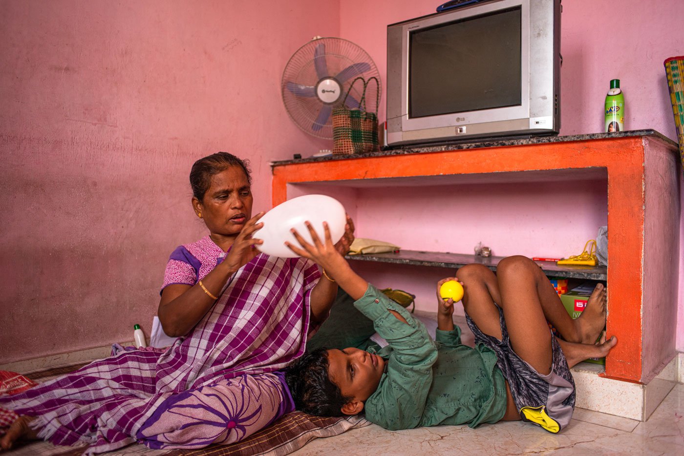 Thangam. R playing with her grandson Manase. She gets a pension of Rs. 1,000 given to persons with disability and she spends it on her grandchildren
