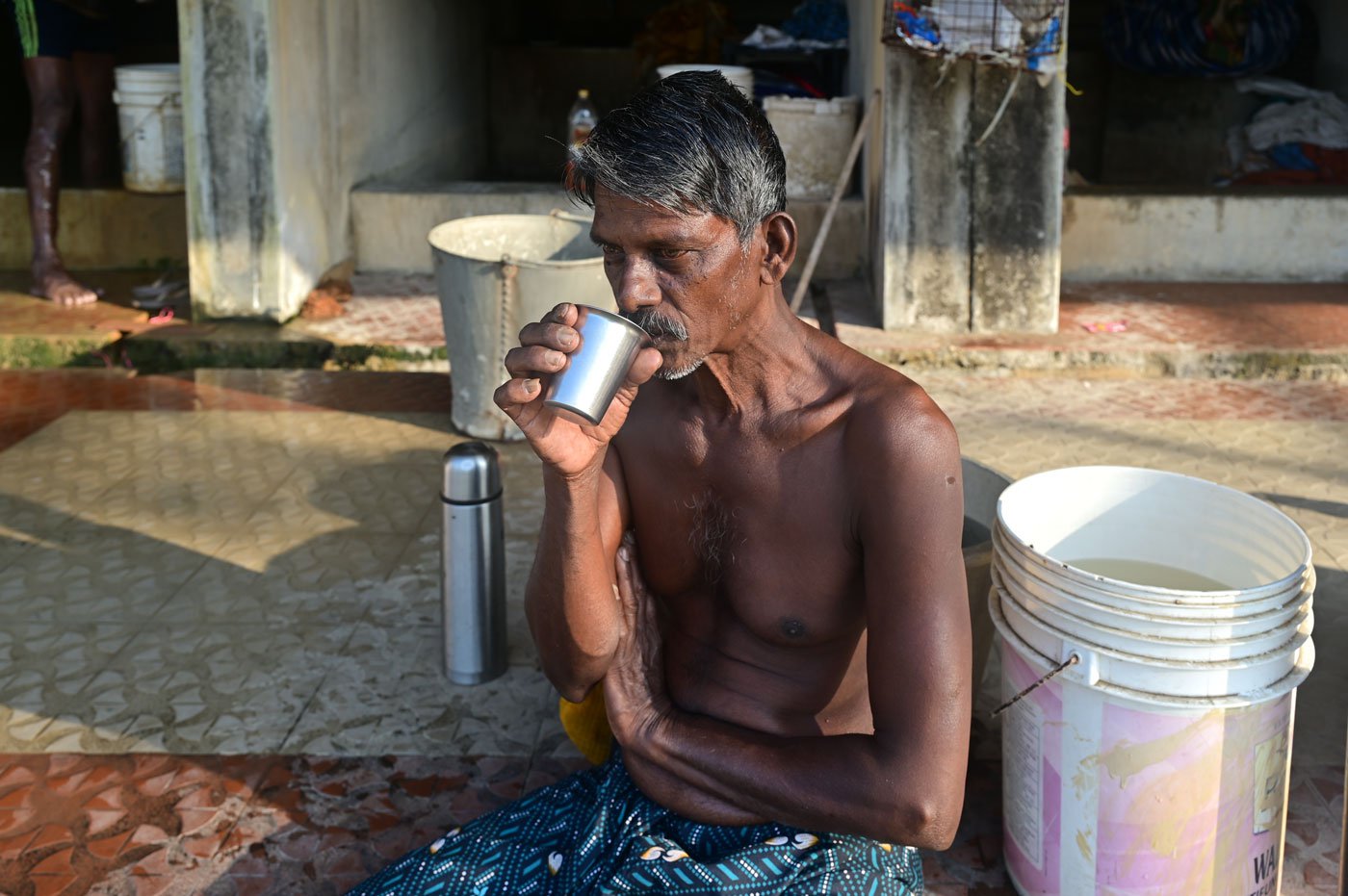 Taking break from his work, a worker sipping hot tea