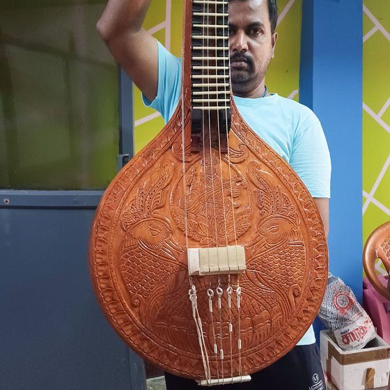Right: Hariharan, who works with Narayanan, holds up a carved veenai