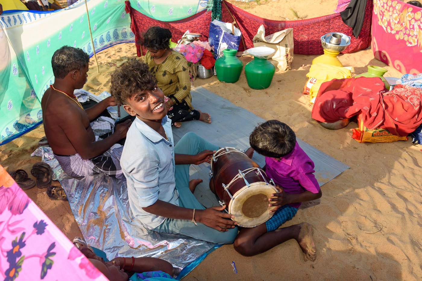 Children playing a modified version of dolkatti (a percussion instrument)