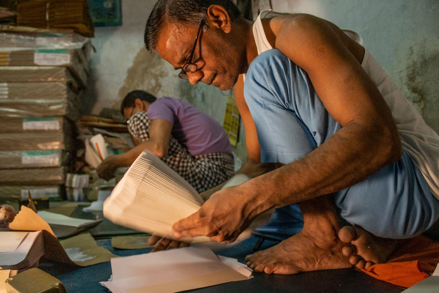 Bhikhabhai Rawal at Taj Envelopes folds the papers to paste the glued right flap on khola , the left flap