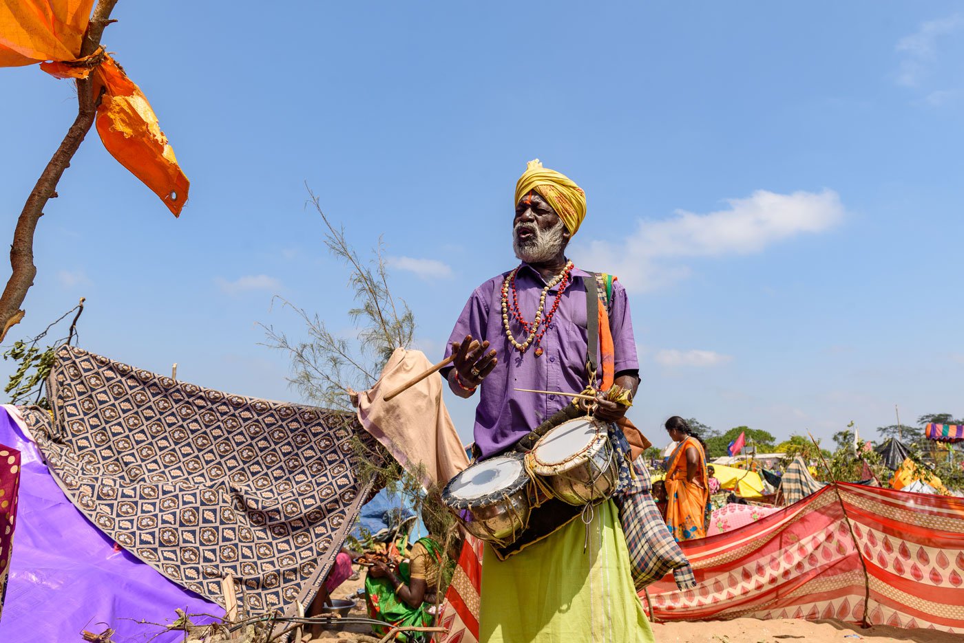 Ayyanar, a pilgrim at the beach, with a twin percussion instrument called kilikattu , handmade by him using two steel pots covered with an acrylic sheet
