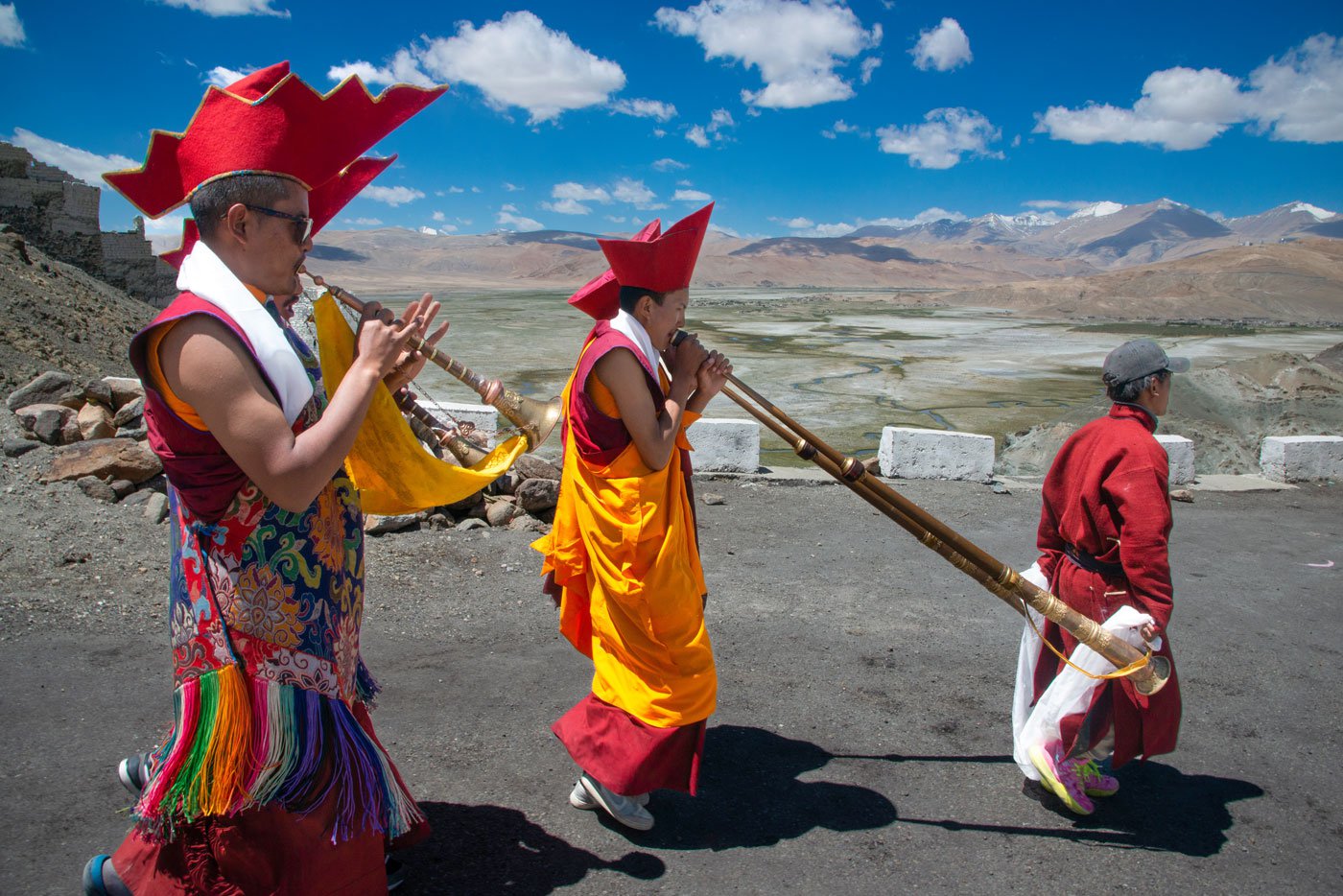 The lamas play traditional musical instruments during this festival. The shorter wind-instrument (left) is called a gelling , and the longer one (centre) is a tung
