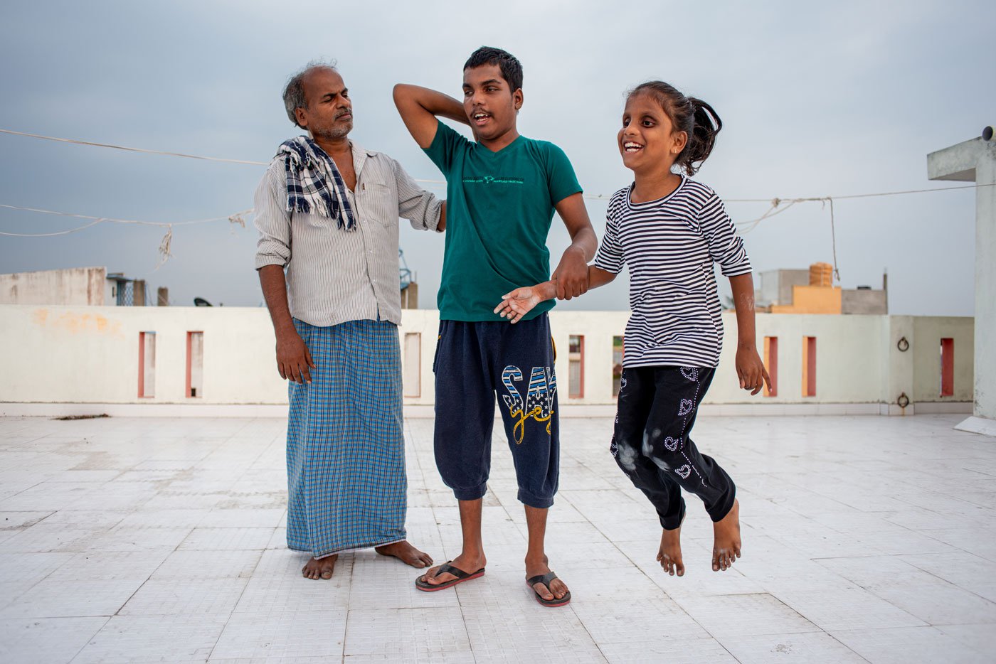 Balaraman (left) takes his eldest grandson Meshak (centre) to the terrace every evening for a walk. Meshak needs constant monitoring because he suffers frequently from epileptic seizures. Sometimes his sister Lebana (right) joins them