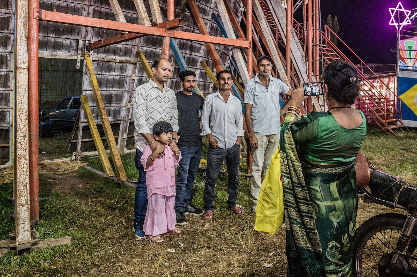 A family takes a photo with Pankaj Kumar, Jagga Ansari and Anil Khan after a performance
