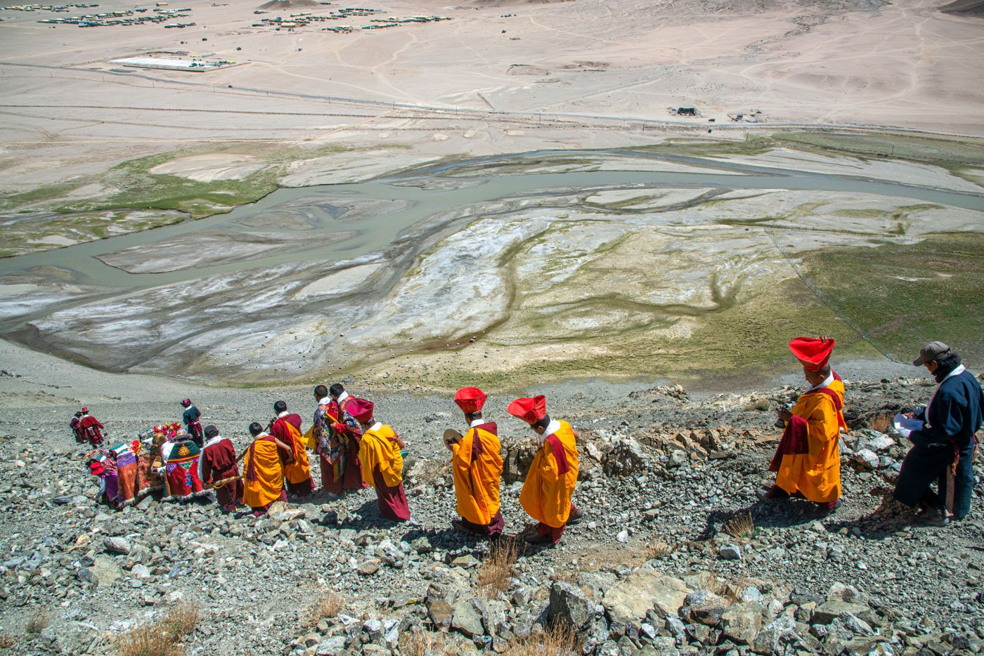 The lamas descend the steep slopes into the Hanle valley as the procession continues