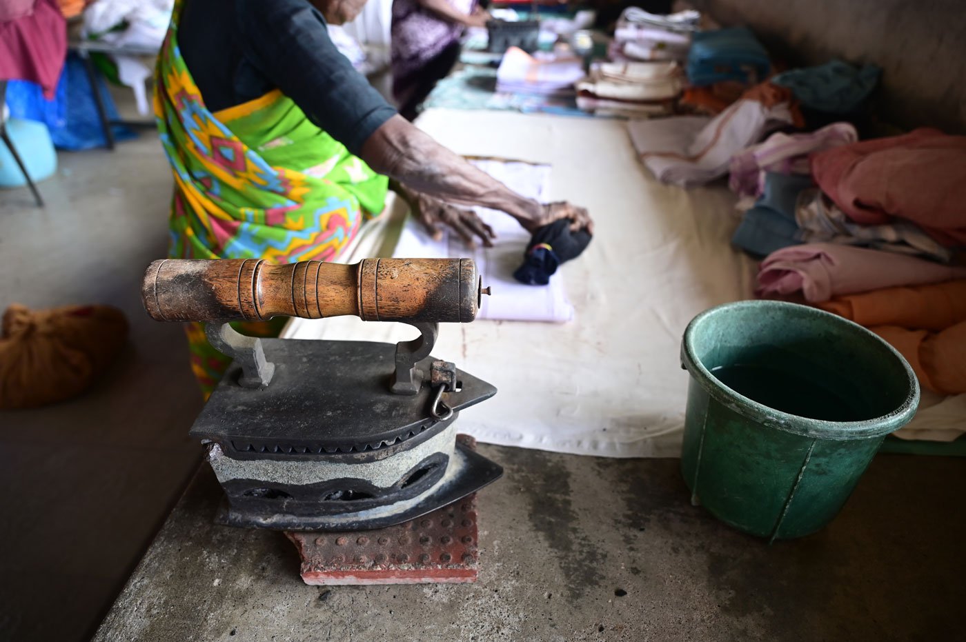 Sarojini uses a sock filled with tiny bits of wet cloth to keep the fabric wet and iron out wrinkles