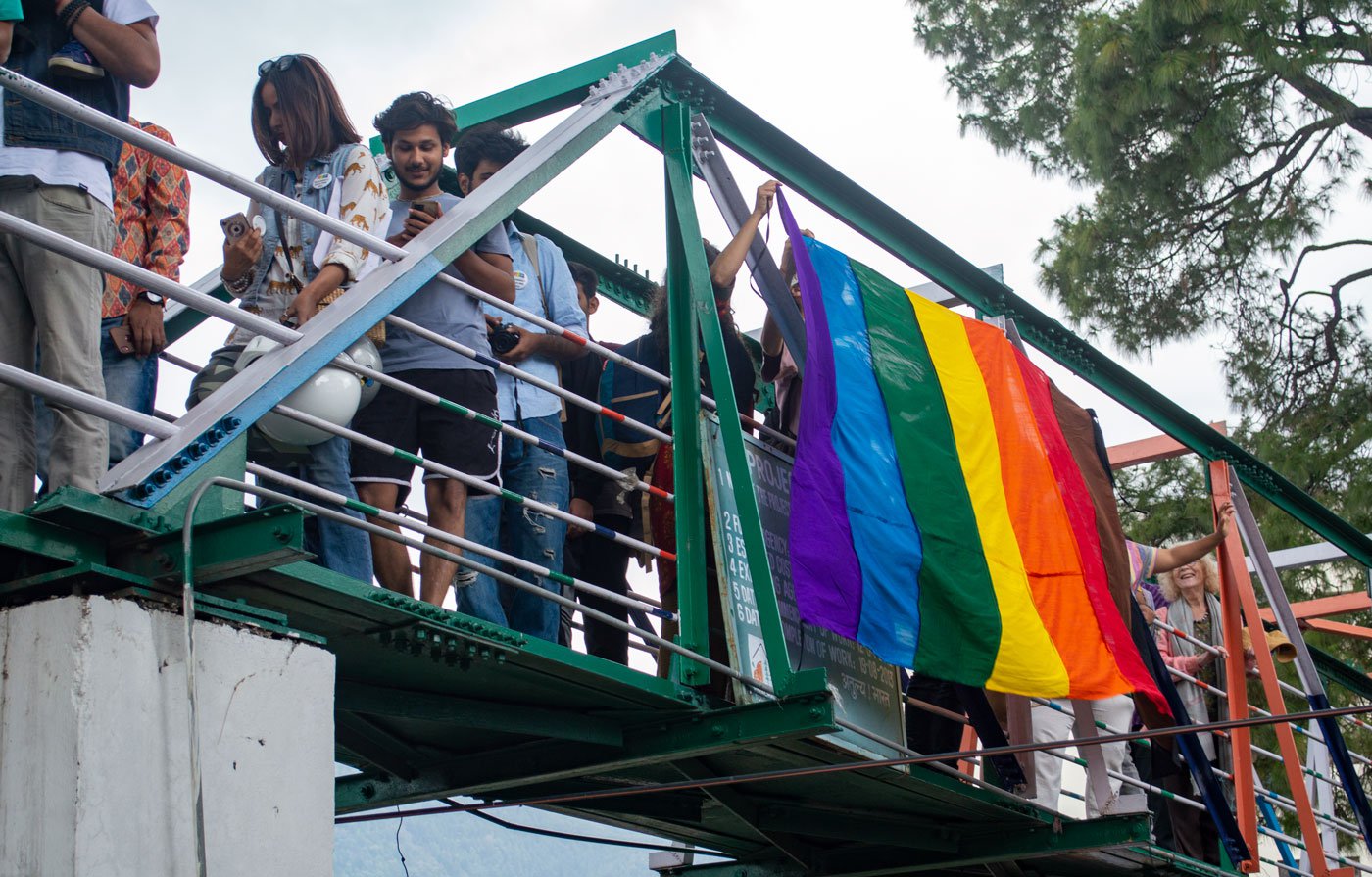 A pride flag hangs from the bridge during the march