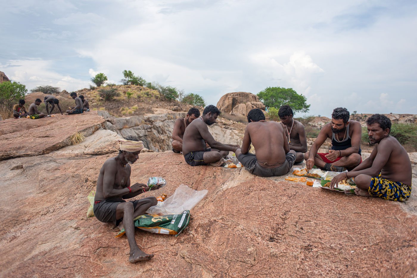 Fishermen eating lunch as they sit on a hillock near Kunnathur lake