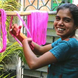 Woman drying coloured yarn