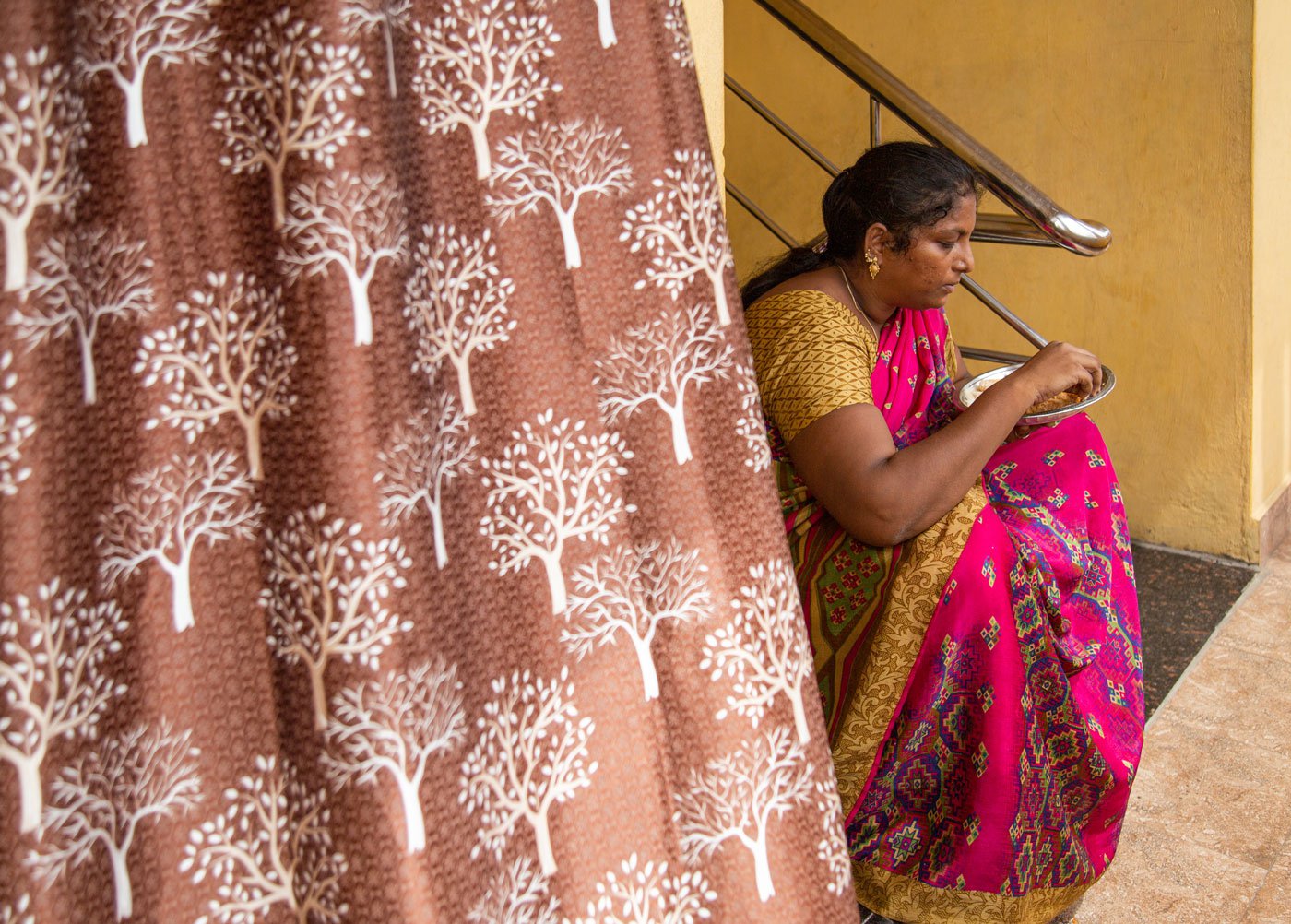 After getting her children ready for school, Saranya likes to sit on the stairs and eat her breakfast. It is the only time she gets to herself