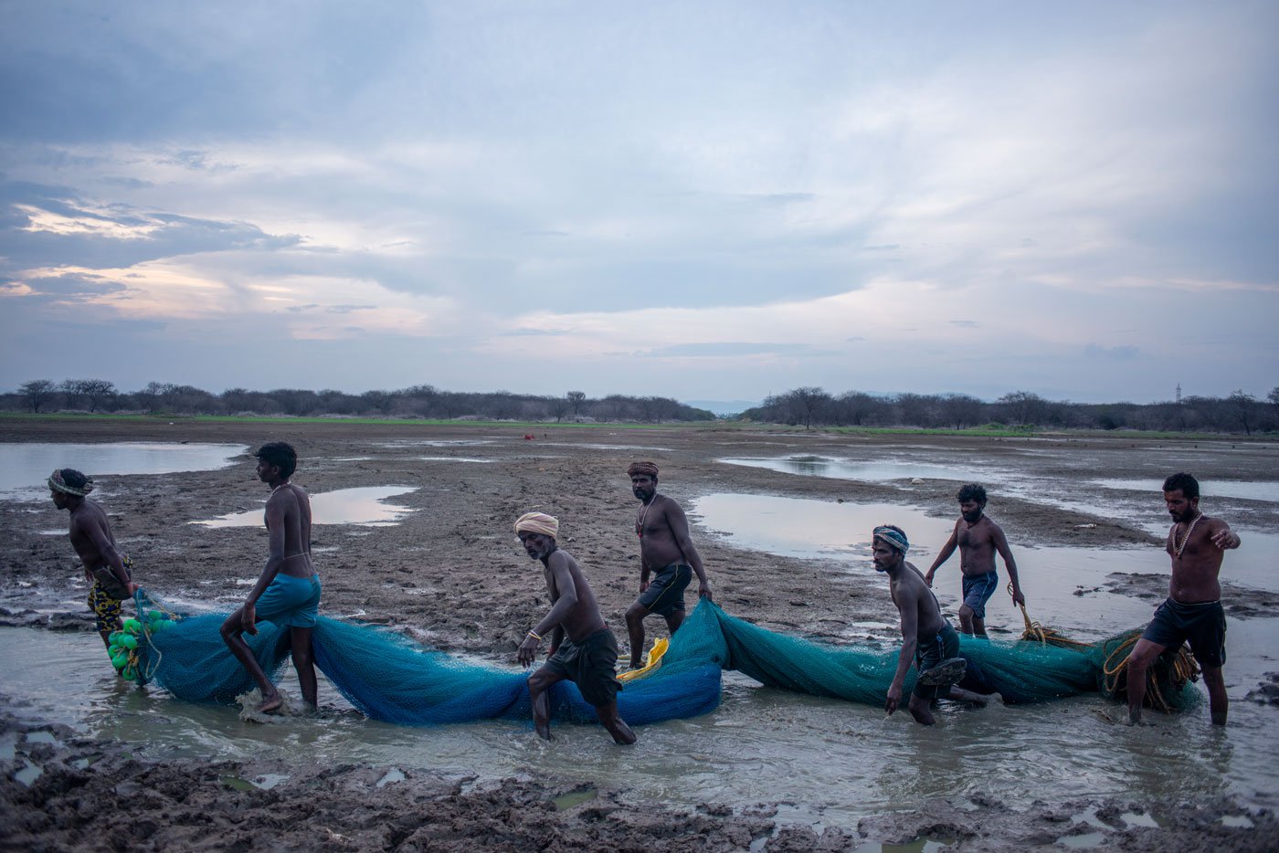 As the fishermen head home, they tie their nets together into a bundle to make it easier for them to carry