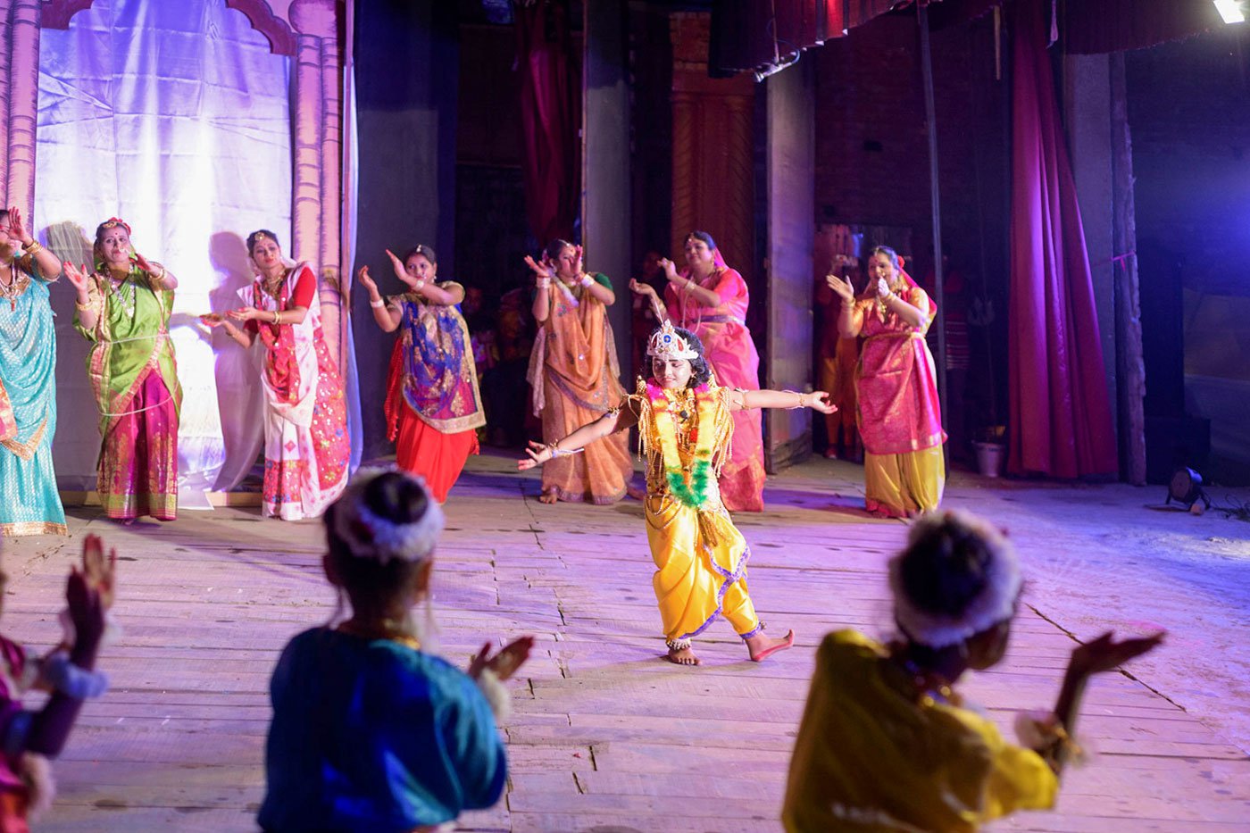 A young Lord Krishna dances with gopis in Vrindavan