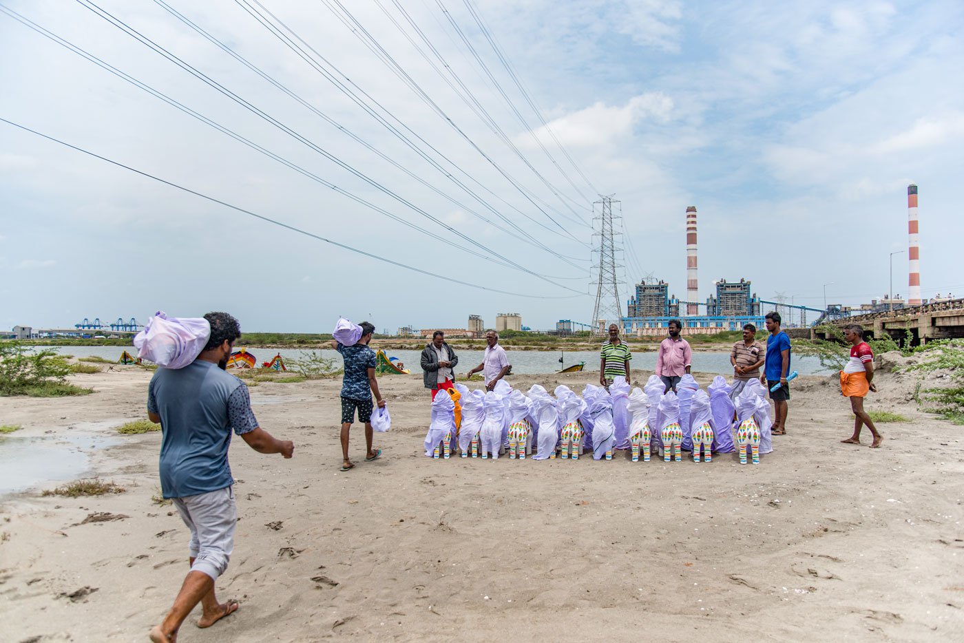 Fishermen carrying idols on their shoulders. From here they will go to their villages by boat. The Kosasthalaiyar river near north Chennai’s thermal power plant, in the background.