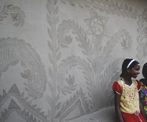 two girls standing against a wall with beautiful handmade designs