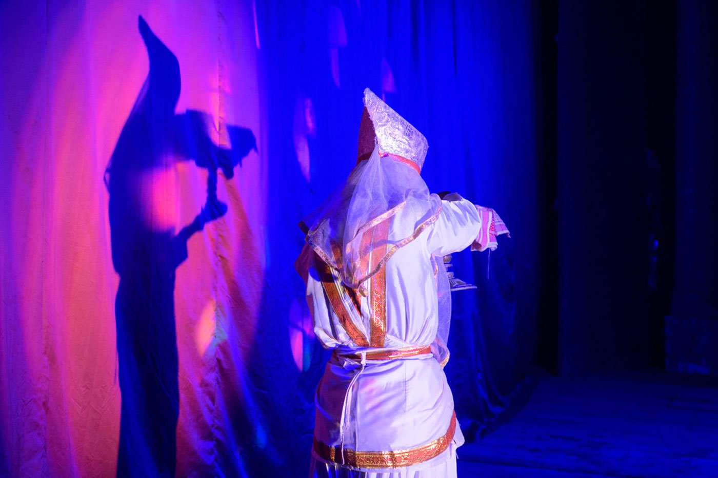 Riki holds up a xorai as he exits the stage after his performance