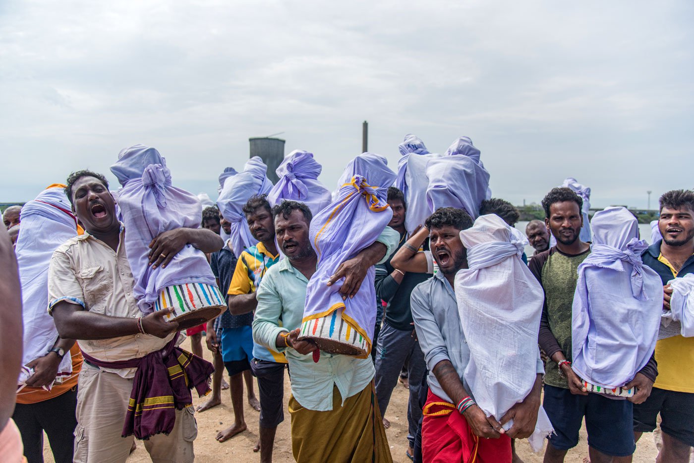 Fishermen shouting slogans as they carry the idols from the boats to their homes