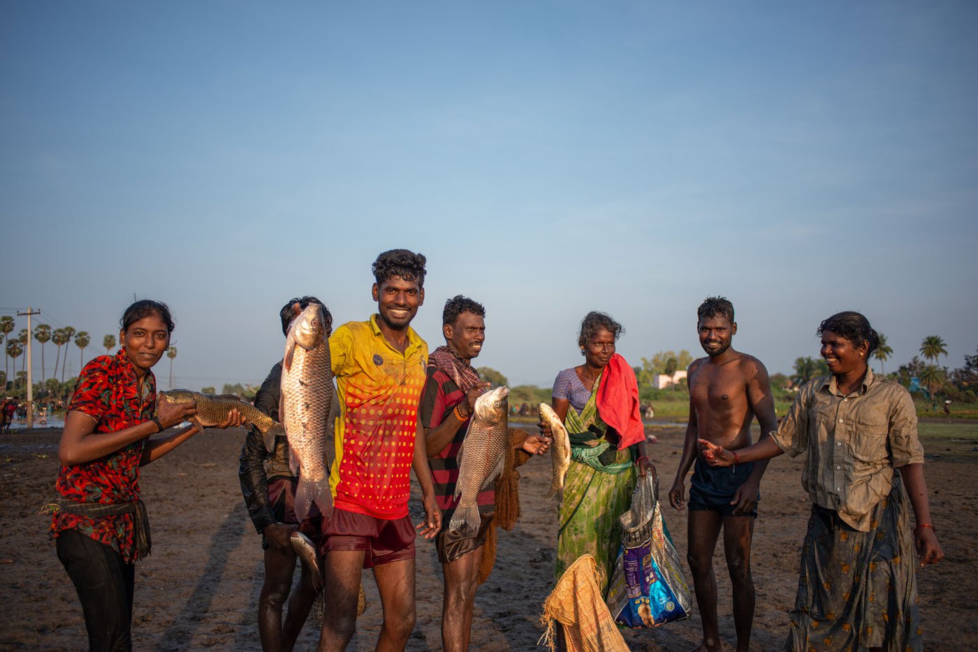 A family from Kallandhiri village show off their catch during the fish harvesting festival