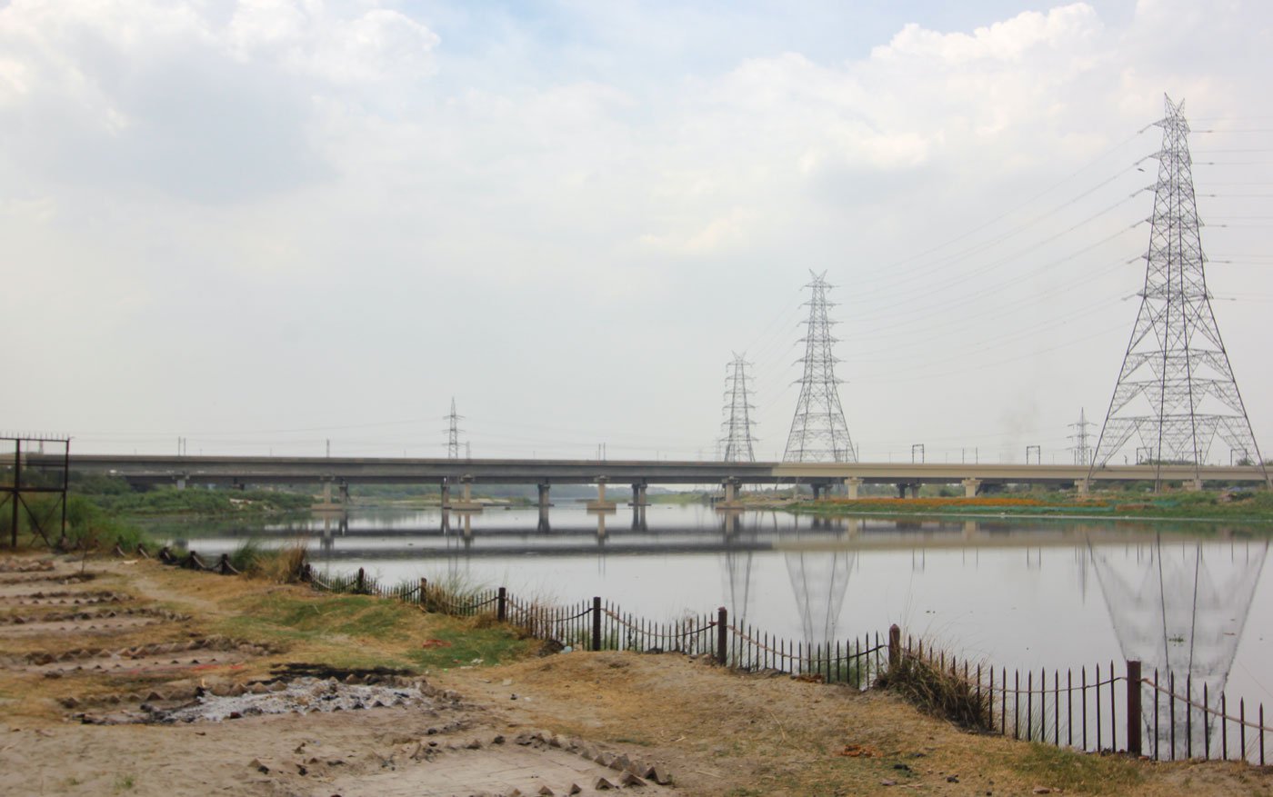 Left: New spots created for pyres at Nigam Bodh Ghat on the banks of the Yamuna in Delhi. Right: Smoke rising from chimneys of the CNG furnaces