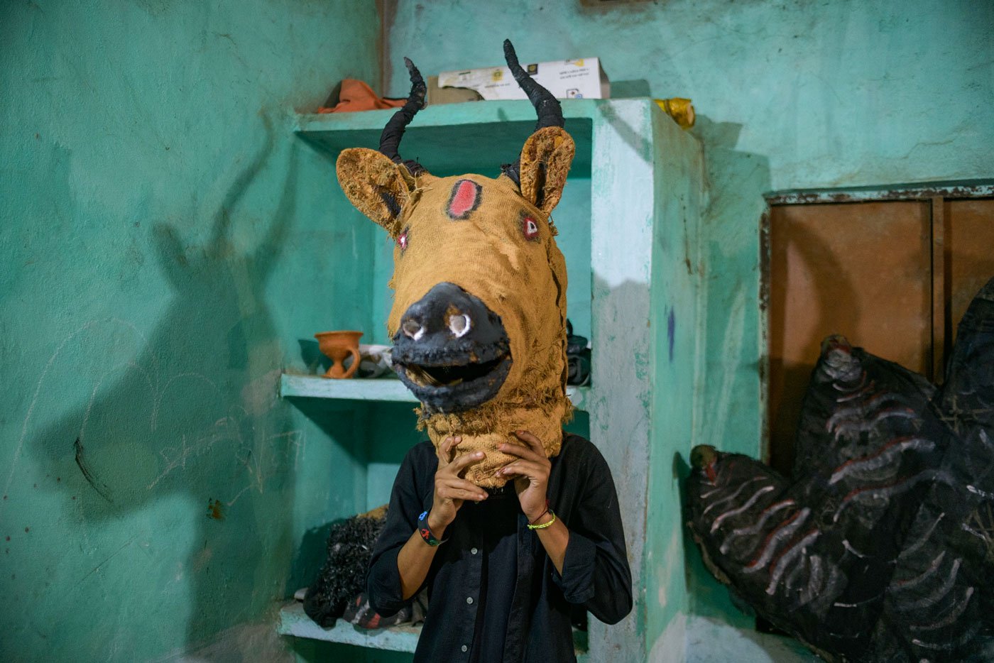 A young boy tries out one of the masks to be used in the performance