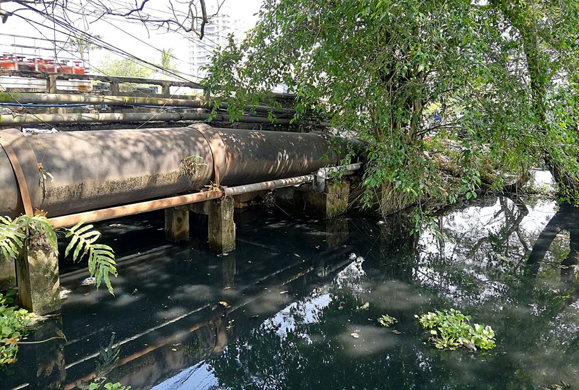 Left: A bridge on the canal that reduces its width and slows down the flow of water. Right: Waste dumped by Kochi city residents on the canal banks