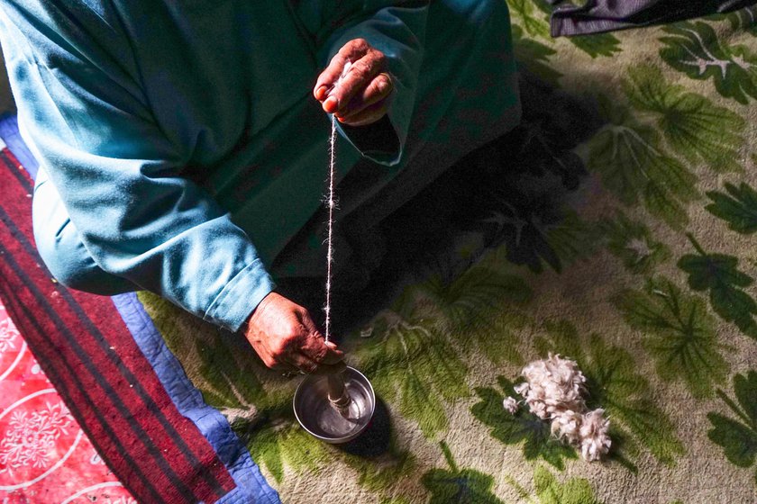 Zooni Begum demonstrates how a chakku is used to spin loose wool into thread