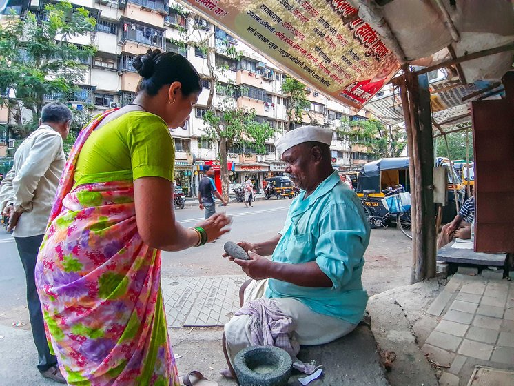 Women buying stone pestle on the road