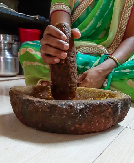 Women grinding on stone pestle 
