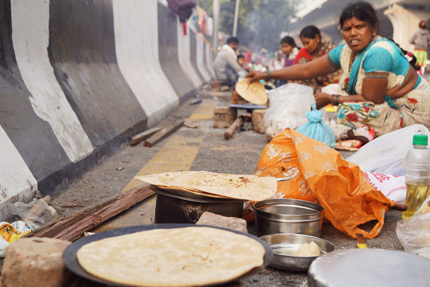 Migrant women cook for their families on the roadside