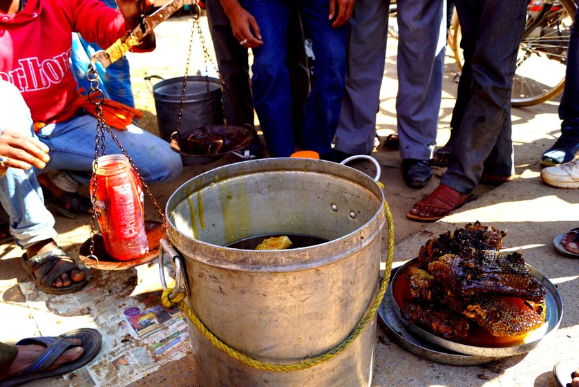 Saibal (in red shirt, pouring the honey) and Ranjit Mandal (not in the photo), along with a few others, at their makeshift roadside honey stall in Nagri tehsil