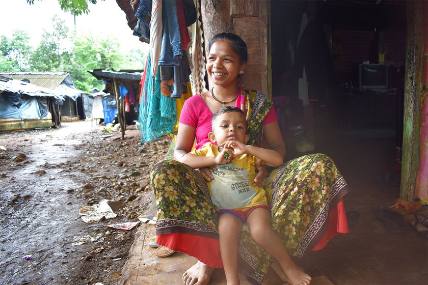 A women sitting at her doorstep with her child