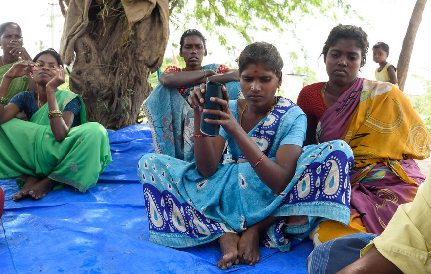 Left: The women of Bangalamedu, an Irular colony in Cherukkanur  panchayat, discuss MGNREGA wages. Right: S Sumathi with her job card. The attendance and wage details on most of the job cards in this hamlet don't tally with the workers’ estimates