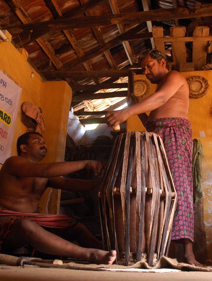 Left: K. Manikandan fastens the leather straps of a mridangam. Right: Ramesh and Rajeevan Lakshmanan finish a maddalam