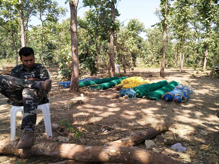  A forest trooper of the Special Task Force taking a break before another gruelling day to find T1 at the base camp near Loni village; behind him are the nets and other material that were to be used in the capture