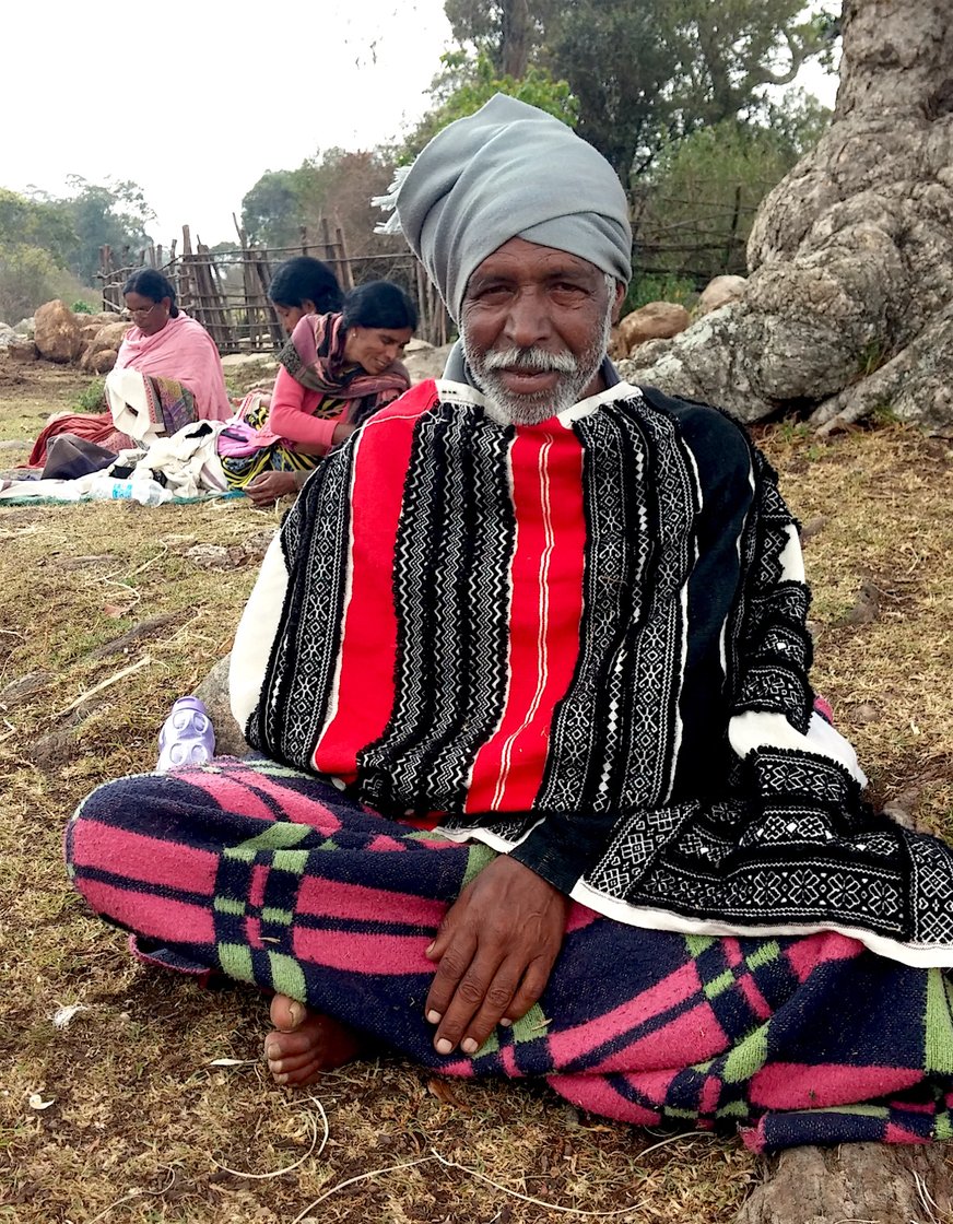 Ooneer Kuttan paused with stripping bamboo and draped in Toda Embroidery