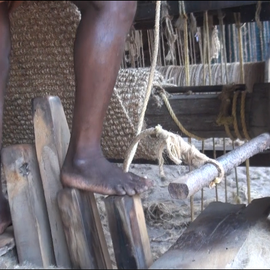 A coir weaver's feet in front of a coir loom