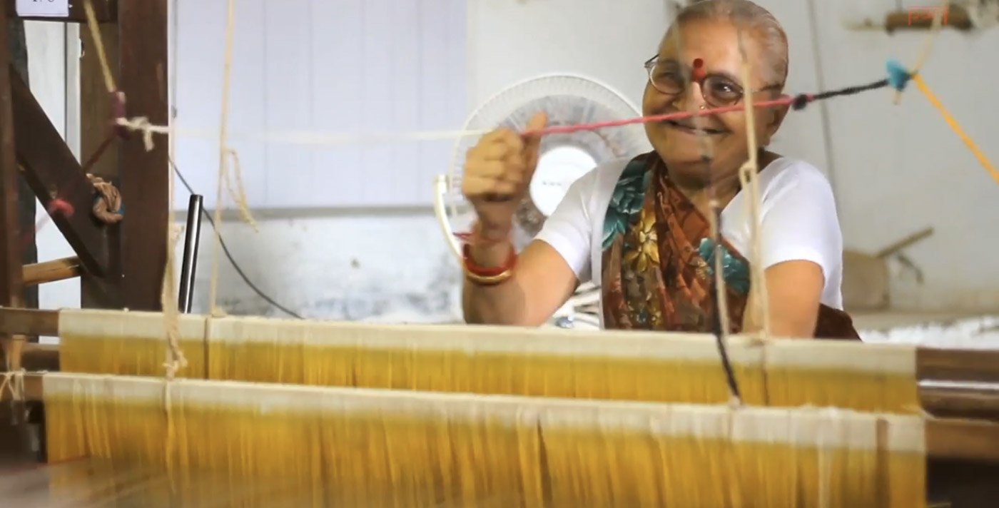 Smiling woman weaving on a handloom