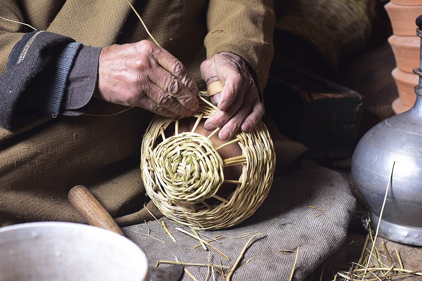 Left: Manzoor Ahmad, 40, weaving a colourful kangri at a workshop in Charar-i-Sharief in Badgam district. Right: Khazir Mohammad Malik, 86, weaving a monochromatic kangri in his workshop at Kanil mohalla in Charar-i-Sharief