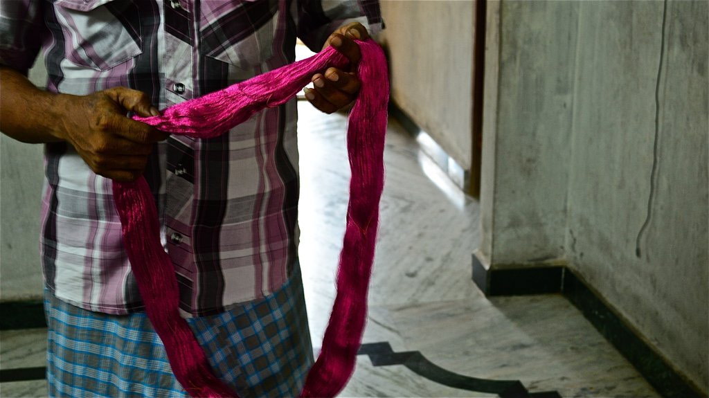 Man holding up silk thread