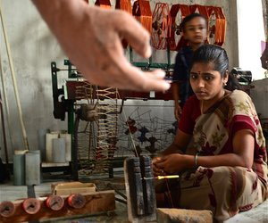 Woman weaving while child looks over