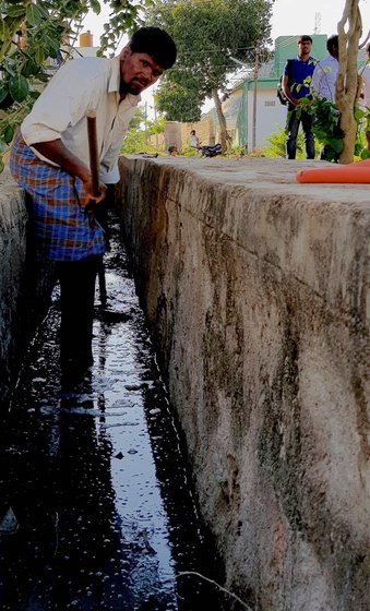 sanitation worker cleaning the gutter