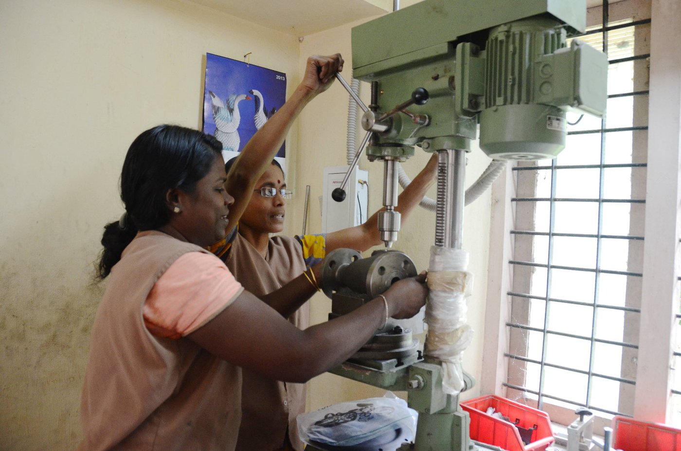 Women working on fabrication machine